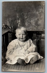 1917 Smiling Baby Girl Sitting On Chair Studio RPPC Photo Antique Postcard