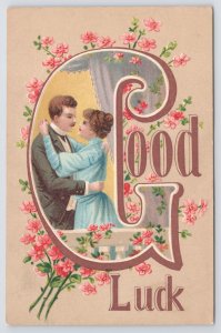 Greetings~Man & Woman Embracing In Big G & Pink Flowers Good Luck~Postcard 
