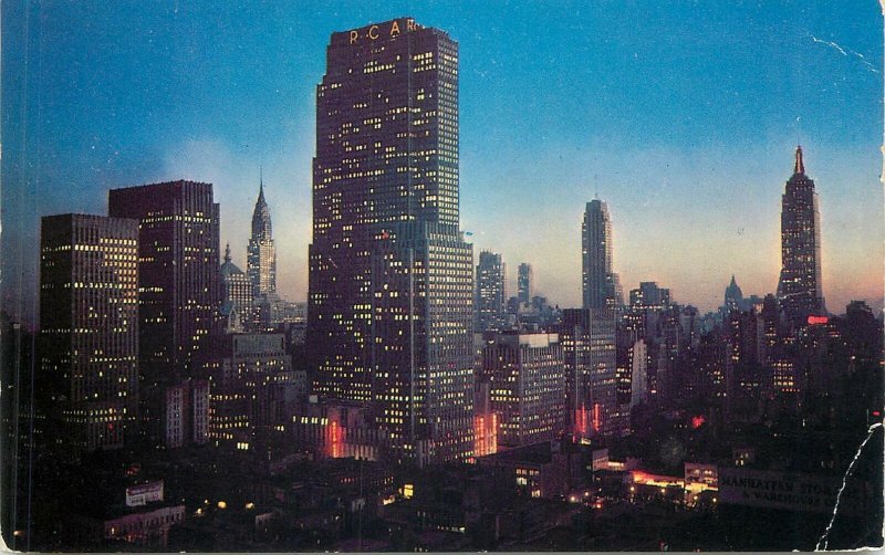 Postcard USA Night falls on Midtown Manhattan showing RCA building Empire state