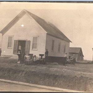 c1910s Small Pioneer Town Church RPPC Moving Furniture Real Photo Postcard A85