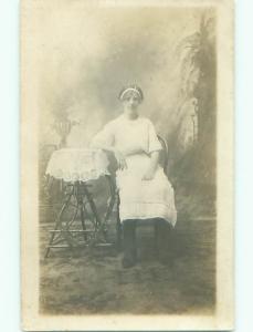 circa 1910 rppc GIRL BESIDE ANTIQUE WOODEN TABLE WITH DOILY o2732
