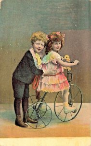 Cute young boy Pushing Beautiful Little Girl on Tricycle~1910 German POSTCRD