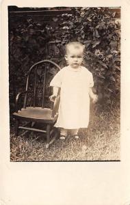 Little child next to a chair Child, People Photo Writing on back 