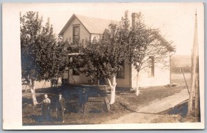 c1910 RPPC Real photo Postcard Family In Front Of Old Farmhouse Dirt Path Trees