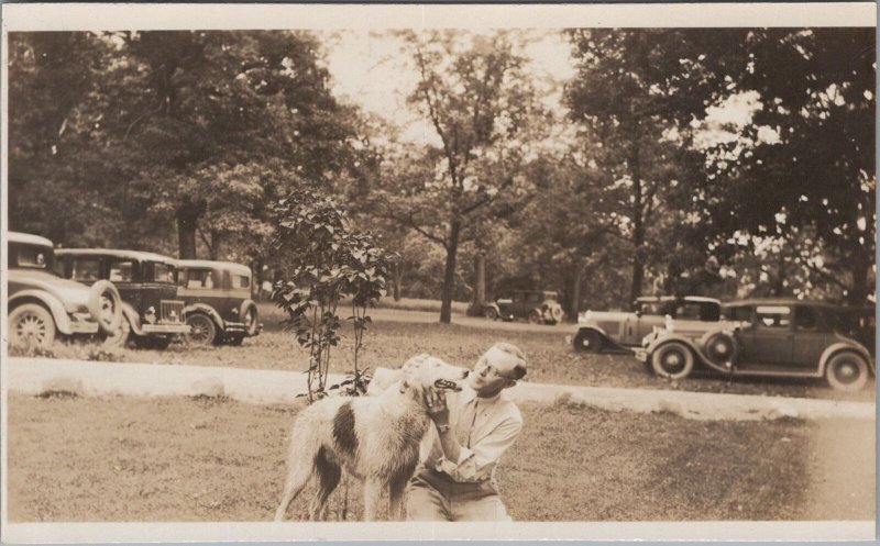 RPPC Postcard Man Playing With Dog In Parking Lot Antique Cars 1930