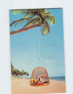 M-121345 Girl relaxes in swing chair on beach San Juan Puerto Rico