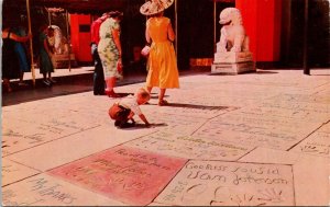 VINTAGE POSTCARD BABY BOY AT MOVIE STARS HAND AND FOOT PRINTS HOLLYWOOD CALIF