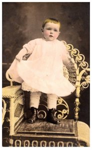 Baby , standing on chair  Colored  RPPC