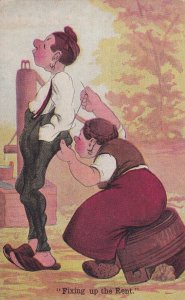 Fixing up the Rent, Woman sitting on stool sewing up pants on woman, 1900-10s