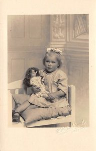Child in a Chair with a Doll Real Photo Writing on Back 