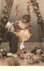 Children couple. Romance on the swing..  Old vintage German postcard