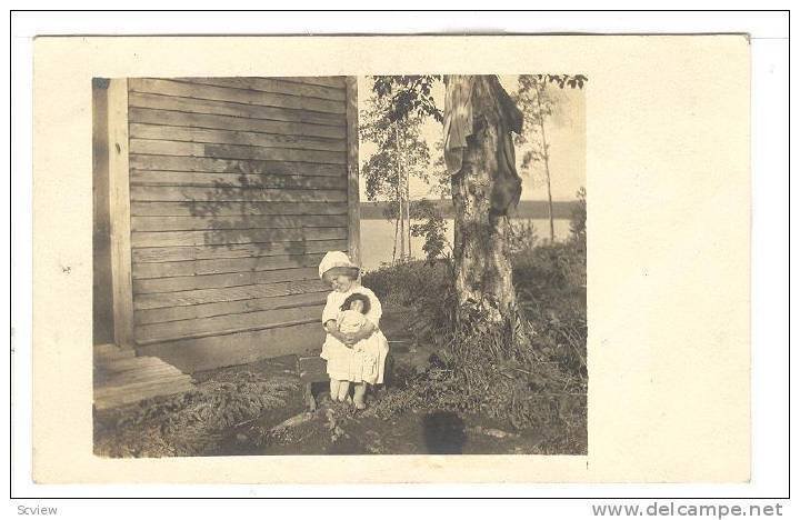 RP; Girl holding doll enjoying the sunshine siting on stool, 10-20s