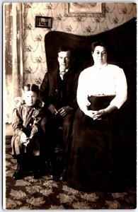 Young Man with Woman and Child Sit on Large Chair Portrait - Vintage Postcard