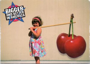 Postcard Exaggeration - Bigger and Better in America - Girl carrying cherries