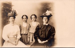 Real Photo Postcard Two Women and Two Young Girls in a Photo Studio