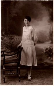 VINTAGE POSTCARD K-LTD REAL PHOTO CARD (RPPC) (1918-1936) STANDING BESIDE CHAIR