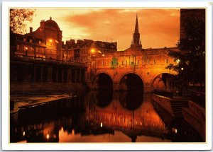 VINTAGE CONTINENTAL SIZE POSTCARD PUTNEY BRIDGE AT DUSK IN BATH AVON ENGLAND U.K