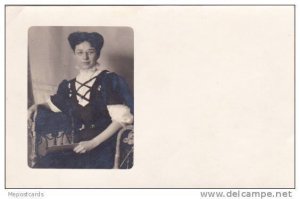 Lady wearing corset top  dress sitting in chair with letter in hand, 10-20s