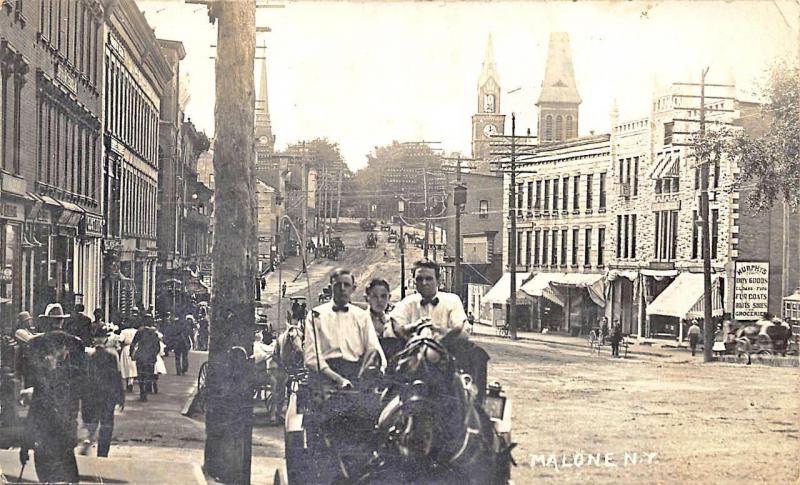 Malone NY Street View Storefronts Horse & Wagon Beach-Series RPPC Postcard