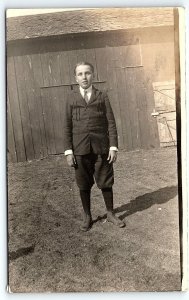 c1910 YOUNG MAN TEEN IN KNICKERS WITH TIE BARN FARM SCENE RPPC POSTCARD P2762