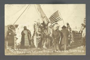 Mott NORTH DAKOTA RPPC 1918 SIOUX INDIANS Indian Trading WHITE MAN Trader FLAG