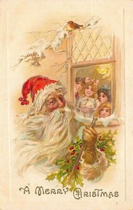 A Merry Christmas Red Suited Santa Claus Four Girls in Window Postcard