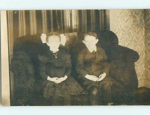 Pre-1920's rppc GIRL WITH BOW IN HAIR ON COUCH WITH BROTHER r6314