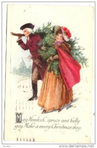 Couple carrying tree and wreath across snow, May Hemlock, spruce and holly ga...