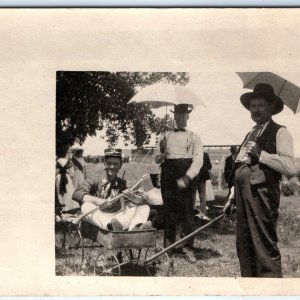 c1900s 4th July MWA Celebration RPPC Goofy Man in Wagon Axe Photo Umbrella A128