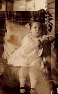 c1910 YOUNG GIRL ON PORCH SWING  REAL PHOTO POSTCARD 25-108