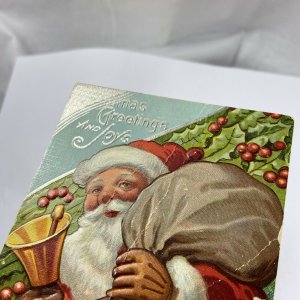 c.1915 Old Santa Claus Bell Toys Sack Bag Stockings Embossed Christmas Postcard
