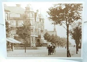 Man Pulling Lady in Bath Chair Sea Rd  Bexhill on Sea East Sussex C1905 Postcard