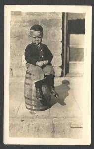 Ca 1913 RPPC REAL PHOTO LITTLE BOY SITTING ON KEG LOOKS SAD