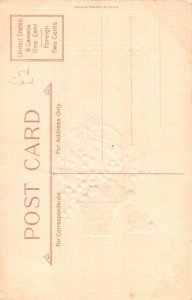 A049 Easter water lilies in basket ribbon chick falling embossed postcard