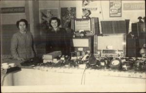 Women w/ Table of Electronics & Signs Old Radio Iron & Others RPPC c1920