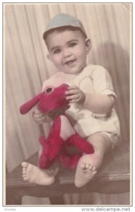 RP; Colored, Happy Toddler Boy holding stuffed toy dog, 1950s