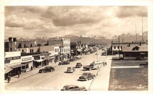 RPPC 4TH AVE EAST ANCHORAGE ALASKA CARS SIGNS REAL PHOTO POSTCARD 1945
