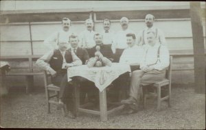 Bowling Team? Men Pose at Table w/ Old Pins & Balls Real Photo Postcard