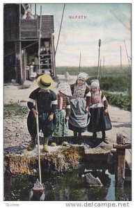 MARKEN, Children playing waterside with toy sailboat, North Holland, Netherla...