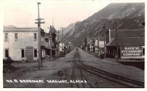 Skagway AK Street View store Fronts Railway Tracks RPPC Postcard