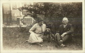 Man & Woman Sitting on Lawn w/ Dog - Irish Setter? c1920 Real Photo Postcard