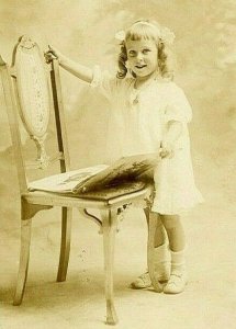 Postcard RPPC Little Girl Viewing an Album on a Victorian Chair.      R7