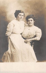 Two Affectionate Women Sitting On One Chair studio rppc AT138