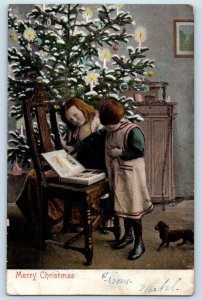 c1905 Christmas Children With Book Candle Lights Puppy Dog Antique Postcard
