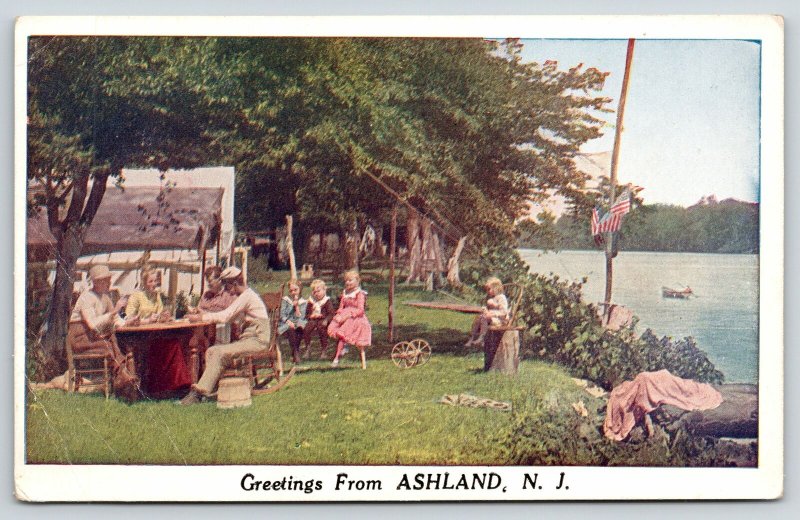 Ashland New Jersey Greetings~Family Outside at Tables~Kids on Stump~c1920 PC 