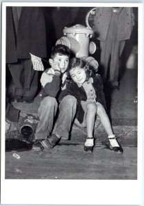 M-66335 Boy and Girl sitting in the middle of a crowd