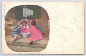 J I Austen~PM 1910~Just Bubbling Over~Group Of Kids Sitting Around Bowl Of Food
