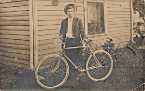 PROUD YOUNG MAN & BICYCLE-MEN PEER AROUND CORNER OF HOUSE~REAL PHOTO POSTCARD