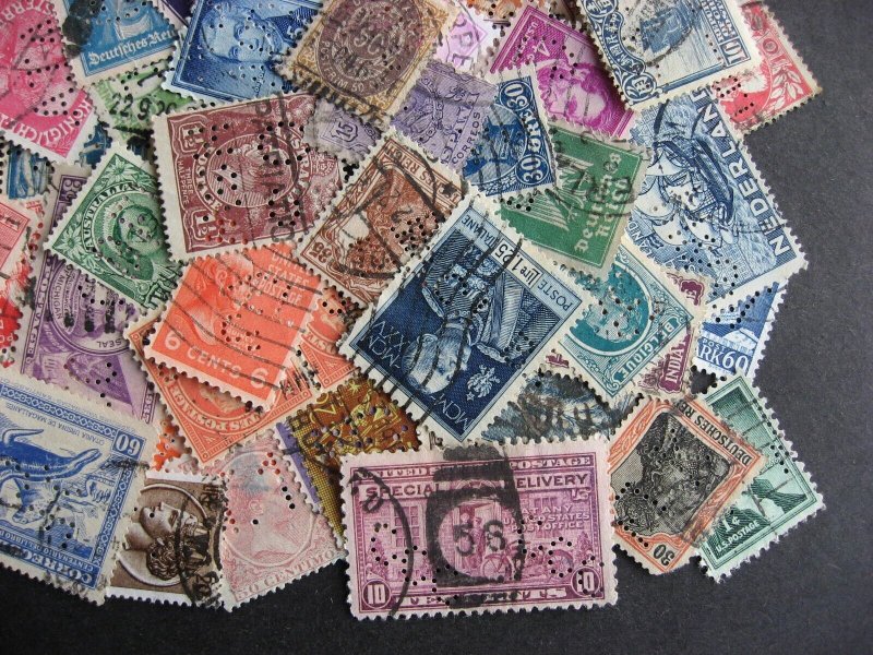 Worldwide perfins, 100 from various countries. Duplicates?, mixed condition. 