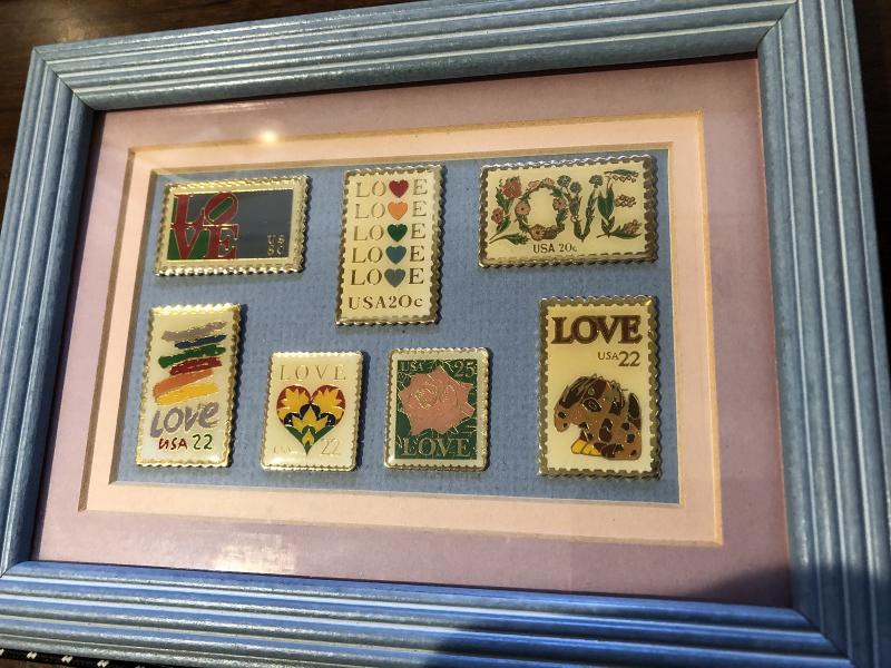 7 Love Stamp Pins Under Glass in a Wood Frame